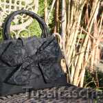 Handtasche aus schwarzer Dupionseide mit bestickter Wechsel-Schleife und Swarowski-Steinen. Innenfutter schwarz-weiß-gepunktet. Verkauft.