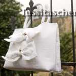 Champagnerfarbene Hochzeitstasche aus Dupionseide mit zwei Zierschleifen und Rosendekoration. Innenfutter flieder. 258,- €