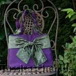 Handtasche aus violettem Stoff mit leichtem Glanz und olivgrüner mit Sternen bestickter großer Schleife. Innenfutter olivgrün. 298.- €